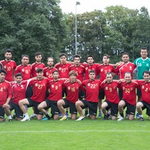 Experte Ali Askar Lali mit den Teilnehmern des Workshops auf dem Fußballplatz. Foto: DOSB/Erlinghagen