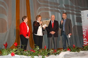 DOSB-Vizepräsidentin Ilse Ridder-Melchers (2. v.l.) überreicht LSV-Präsident Dr. Ekkehard Wienholtz und LSV-Vorstandsmitglied Sylvia Nowack die Siegerurkunde des DOSB. Ganz rechts Moderator Ralf Huber. (Foto: LSV SH)