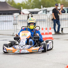Ein Jugendlicher im Kart fährt zwischen rot-weißen Kegeln hindurch