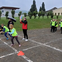 Zwei Schüler*innen beim Start zum Sprint, im Hintergrund weitere Schüler*innen in grünen Westen